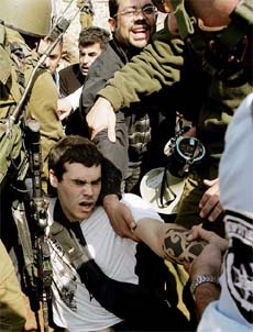 Israeli troops scuffle with a protester during a demonstration against the controversial Israeli barrier in the West Bank village of Abud, near Ramallah