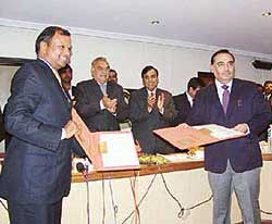 The Managing Director of the Haryana State Industrial Development Corporation, Mr Rajeev Arora, and a Director of Reliance Industries Limited, Mr Anand Jain, after signing an MoU for a special economic zone in Haryana at Chandigarh on Monday. Mr Bhupinder Singh Hooda, Chief MInister, and RIL Chairman Mukesh Ambani, are also seen in the picture.