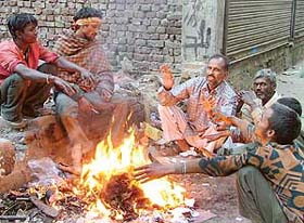 Ragpickers keep the cold at bay by lighting a camp fire in Ludhiana