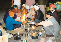 All gather around the fire that cooks the meal to soak its warmth 
