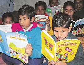 Children from Oriya families read a Gurmukhi primer in school
