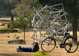 A man lying in the sun in Leisure Valley, Chandigarh, looks like a sculpture himself.