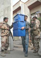 An Iraqi Election Commission official carries a ballot box from an election centre in Baghdad on Friday. 
