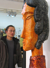 A Chinese visitor looks at a statue created by a graduate during a job fair at the Nanjing Arts Institute in Nanjing, China, on Saturday.