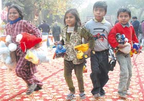Poor children carrying toys collected from Toys Bank which houses donated and collected toys which are given free to underprivileged children, in the Capital