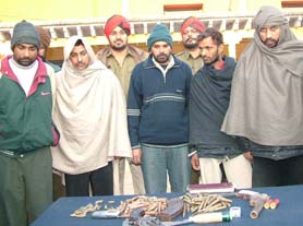 Members of the robbers gang in police custody along with the cache of arms and ammunition recovered from them in Jalandhar on Saturday.