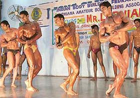 Participants in the Ludhiana District Bodybuilding Championship flex their muscles