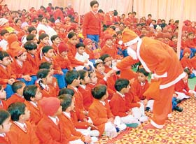 Santa Claus distributes sweets to students of St Thomas School at a Christmas function