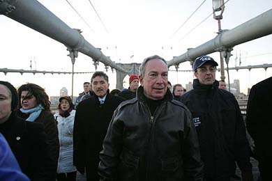 New York Mayor Michael Bloomberg walks across the Brooklyn Bridge with other commuters during the morning rush hour in New York on Tuesday