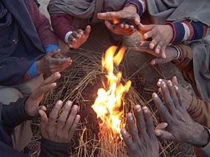 As the mercury dips, some gather around a bonfire.