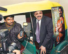 Union Minister for Communications and Information Technology Dayanidhi Maran (in the back seat) after presenting a new low-cost mobile handset to an autodriver in New Delhi on Thursday. 