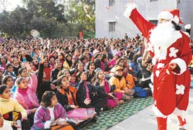 Santa Claus distributes sweets among children at a Christmas celebration function at Sacred Heart Senior Secondary School, Sector 26, in Chandigarh on Thursday. 