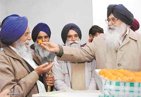 The President of the Shiromani Akali Dal, Mr Parkash Singh Badal, offers sweets to elected members of gurdwaras in Haryana, at a function in Chandigarh