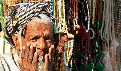 An earthquake survivor sells prayer beads in front of a mosque in Muzaffarabad