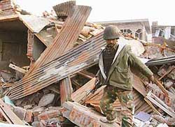 A soldier stands in the rubble of a house, which was destroyed in an encounter with militants at Bemina on the outskirts of Srinagar on Sunday. 