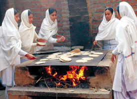Students busy making chapattis in the kitchen of the Baba Aya Singh Riarki College for Women in Tughalwala.