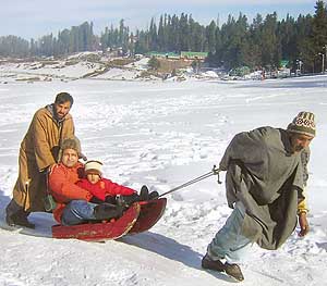 A tourist enjoys a ride on a sledge at Gulmarg on Sunday.