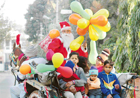 Santa Claus greets people while riding a horse cart in Ludhiana on Sunday