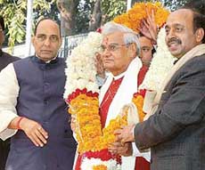 Former Prime Minister Atal Bihari Vajpayee is presented with a garland on his 81st birthday by senior BJP leaders Rajnath Singh (left) and Vijay Goel at the former's residence in New Delhi on Sunday. 