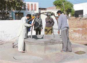 Villagers at the well where the body of an 18-day-old child was found in Baroli village near Kharar on Sunday. 