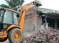 A bulldozer pulling down an unauthorised construction in Mahipalpur in the Capital.