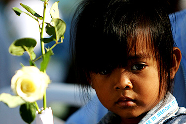 A Thai girl holds a white rose at the Mai Khao Memorial Wall in Phuket on Monday