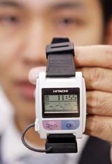 A Hitachi engineer displays a wrist-watch shaped sensor node