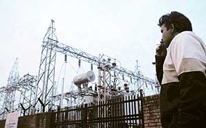 A passerby walks past a power grid in Chandigarh on Tuesday. Electricity production grew by 4.9 per cent this fiscal as against 6.7 per cent in the same period last fiscal. 