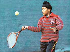 Inderbir Singh Bains returns a shot against Akhil Bansal in the under-10 tennis tournament in Chandigarh on Tuesday. 