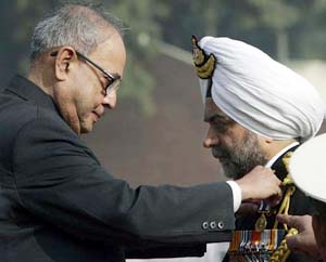Defence Minister Pranab Mukherjee presents the President's Tatrakshak Medal to Inspector-General Surinder Pal Singh Basra during a Coast Guard investiture ceremony in New Delhi on Tuesday