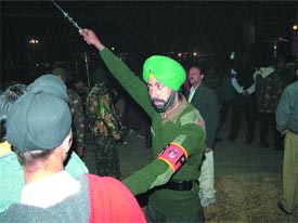 An army personnel wields the stick to disperse the crowd during the Jazzy B With Faujis function in Jalandhar on Tuesday night