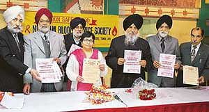 Dr Manorama Awasthi, Mr H.S. Pahwa and functionaries of the Niskam Blood Service Society release the motto of the society in Ludhiana on Wednesday.