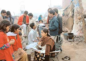 Students of the NGO Theatre Age conducting surveys in a city slum
