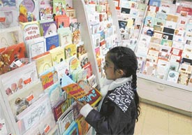 A girl finds it difficult to choose a New Year greeting card from the variety on display at a store in Ludhiana