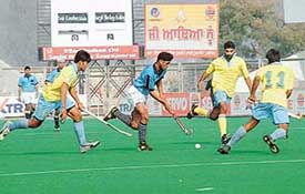 Centre of Excellence players try to stop a Surjit Hockey Academy player  during a match in the Surjit Memorial Hockey Tournament in Jalandhar on Friday
