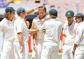Australian paceman Glenn McGrath is congratulated by team-mates after dismissing 