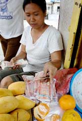 A fruit vendor counts peso notes at a market in Manila on Monday. 
