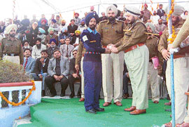 Punjab Police chief S.S. Virk honours a community police officer at Khanna on Monday.