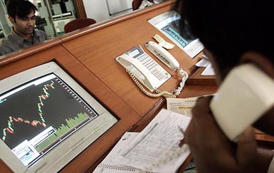 A stockbroker speaks to clients on the telephones as he studies share prices on the monitor in Mumbai on Tuesday.