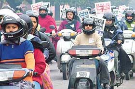 Working women and girl students from various colleges participate in a scooter rally organised by the Chandigarh Police