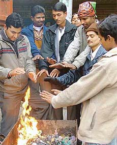 With a dip in mercury, workers gather around a fire to keep themselves warm in Ludhiana