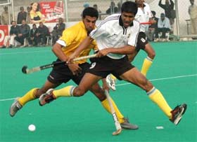 Bharat Petroleums Amar Ayama (white) and Punjab & Sind Banks Davinder Bath (yellow) fight for the ball during a quarterfinal match of the 22nd Surjit Memorial Hockey Tournament in Jalandhar