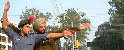 A traffic police personal trains an NCC cadet to control the flow of vehicles on the road crossing as part of the annual camp of the air wing of the NCC held in city recently