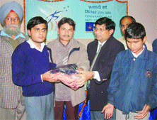 Mr Suresh Kumar Jain, Zonal Manager, Bank of India and Mr Paramjit Singh, ADC distribute bedsheets and sweaters at the Institute for Blinds here recently