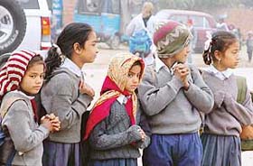 Children brave the chill while going to school as the city reeled under the cold wave