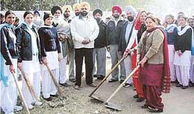 Volunteers of Guru Har Krishan College, Phallewal, clean streets as part of their 10-day NSS camp at Akbarpur village, near Ahmedgarh