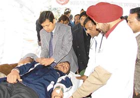 The Deputy Commissioner, Mr Anurag Verma, places a blood donation badge on a volunteer in Ludhiana
