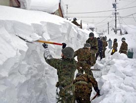 Japanese soldiers help residents clear snow in Liyama city, Nagano prefecture, on Saturday. The Self-Defence Force dispatched a disaster relief unit to Liyama for the expected heavy snowfall in coming days