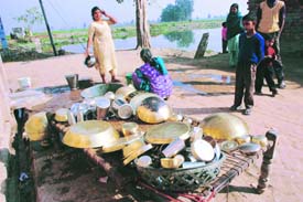 Braving the winter chill, these village women are busy giving a finishing sheen to brass utensils