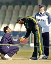 Shahid Afridi shakes hands with Sourav Ganguly as Indias coach Greg Chappell looks on prior to their practice session at the Gaddafi Stadium in Lahore on Thursday